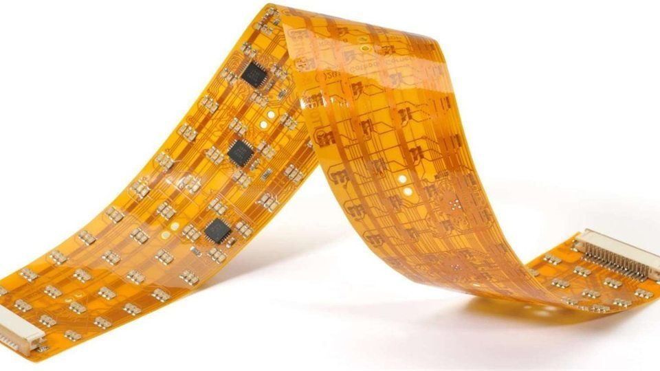 Amber flexible circuit folded into a bend with visible traces and components
