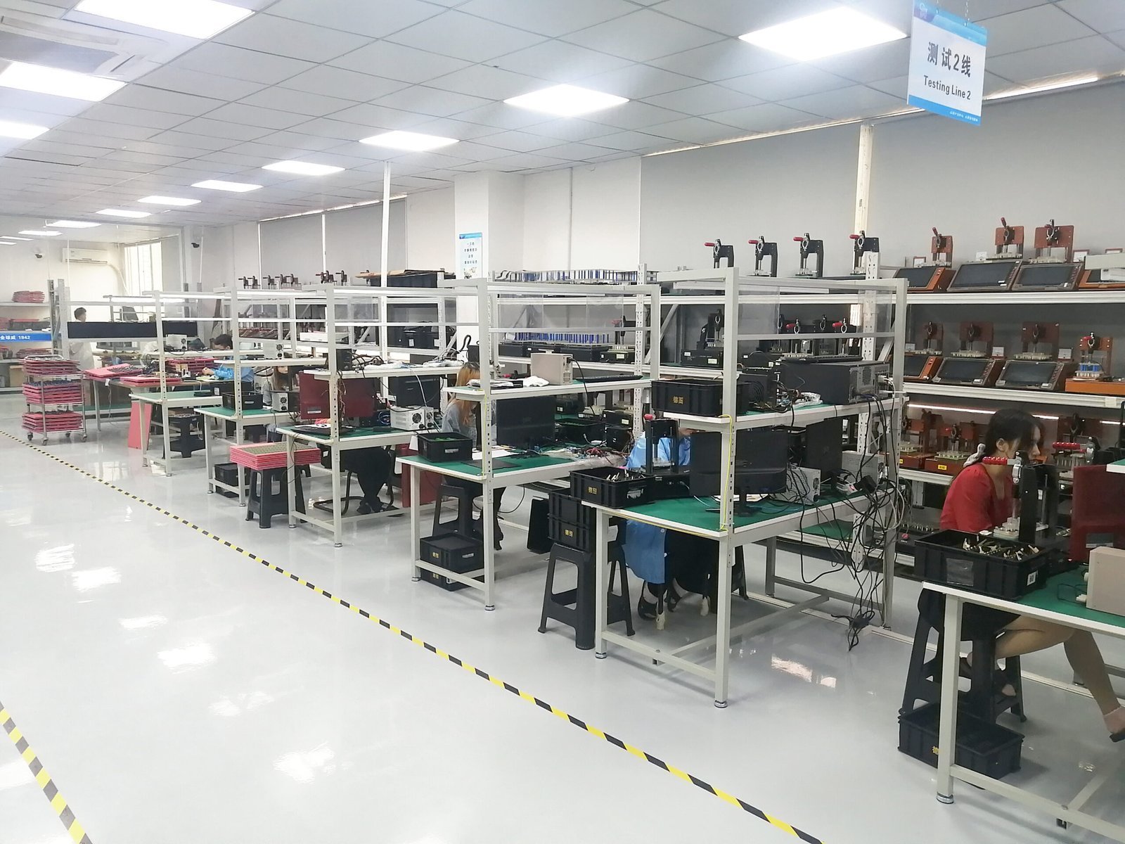PCBA testing room with workstations, test equipment and technicians