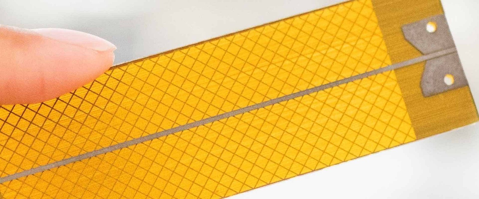 Flexible circuit copper mesh | GlobalWin Close-up of a mesh pattern on an amber flexible circuit sheet