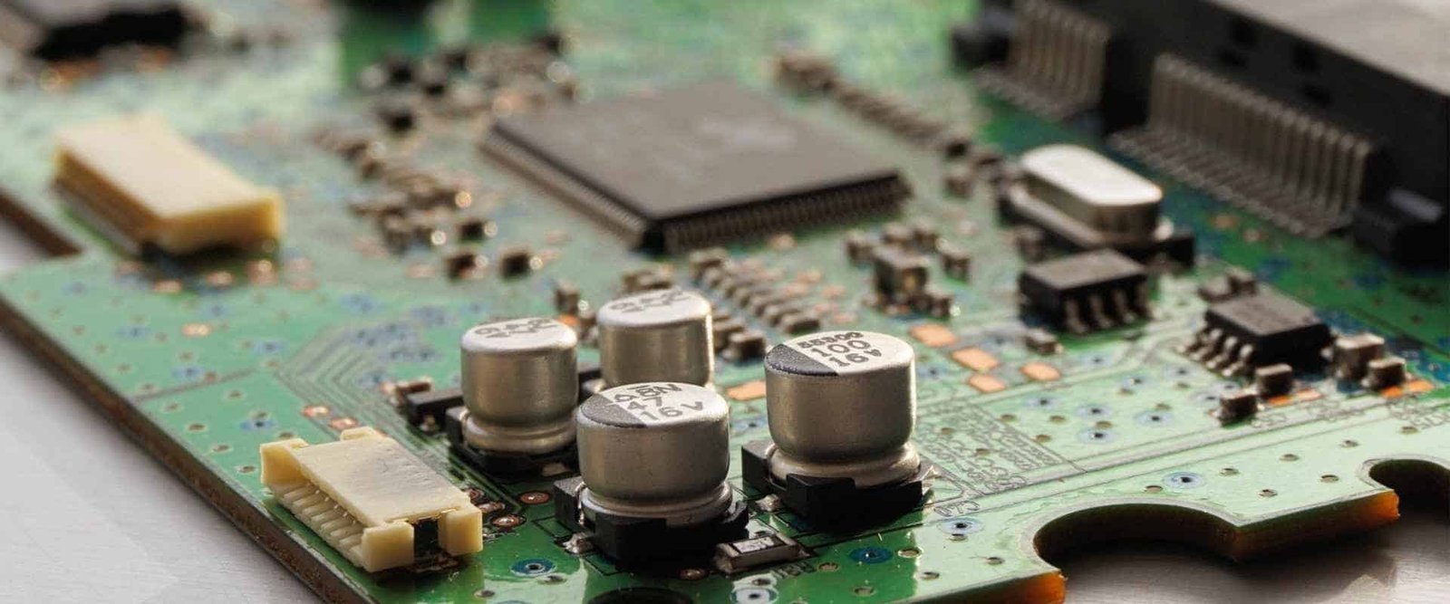 Populated green circuit board with integrated circuits, capacitors and connectors