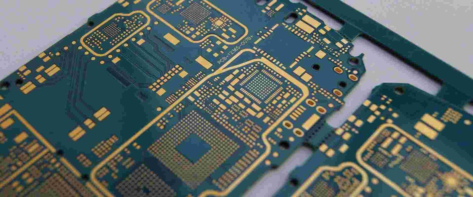 Fine-pitch circuit board pads | GlobalWin Close-up of a blue circuit board with fine-pitch pads and closely routed traces